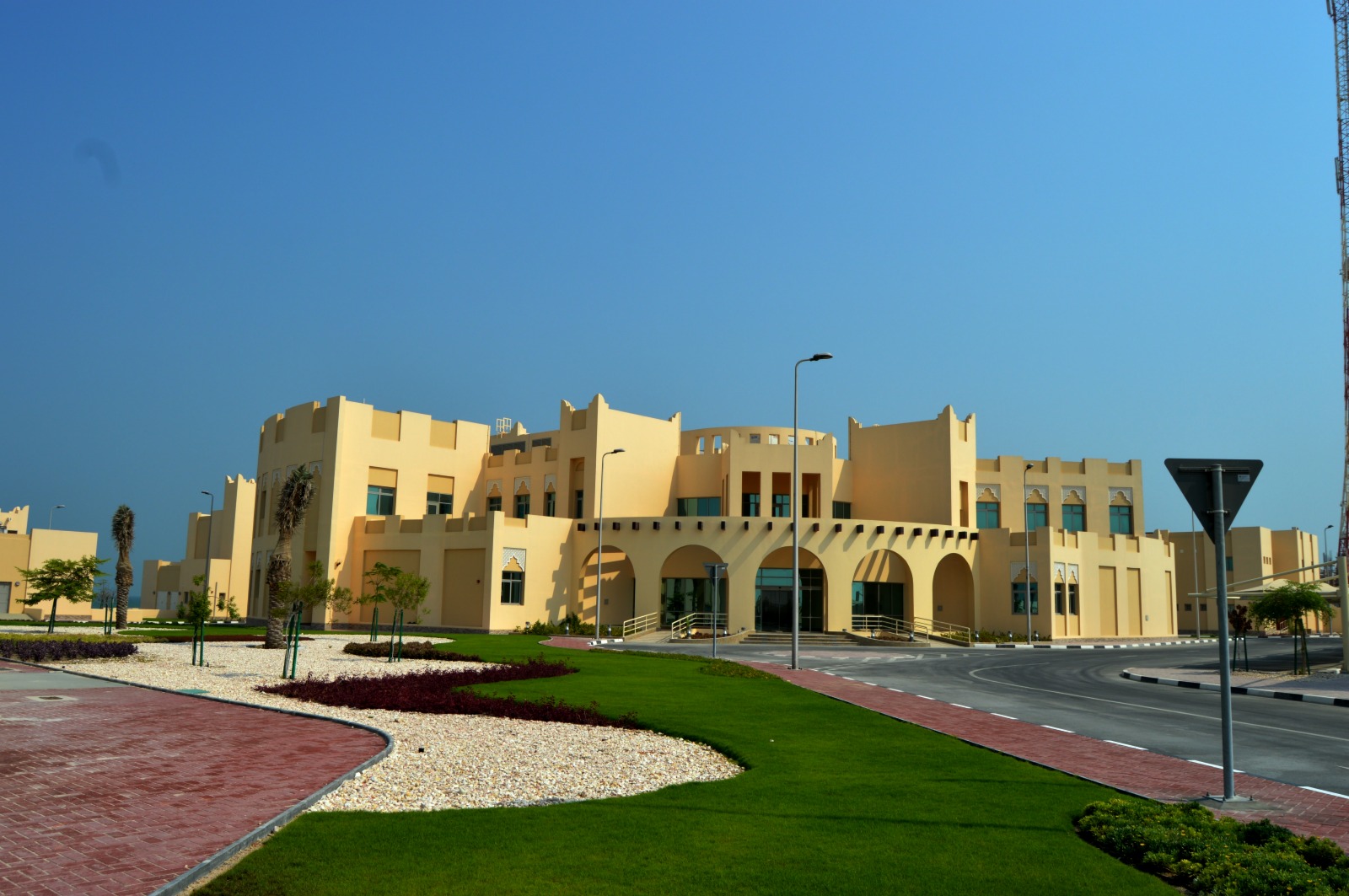 Landscaped lawn and paved garden beside a building in Qatar